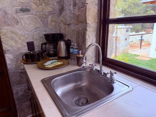 a sink in a kitchen with a stone wall at Royal Fest By GEstores in Huasca de Ocampo