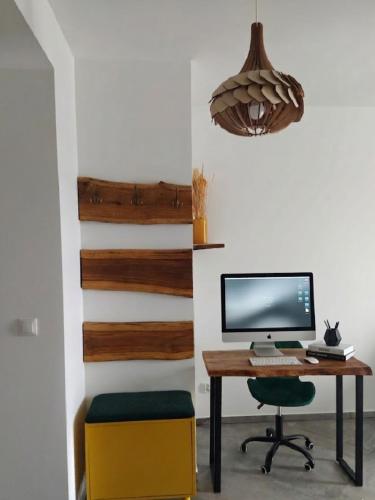 a desk with a computer and a chair in a room at Apartament na Bora in Tarnów
