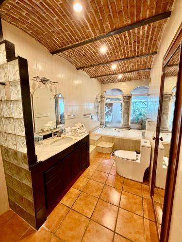 a bathroom with a tub and a toilet and a sink at MiraLago Pool Paradise in San Antonio