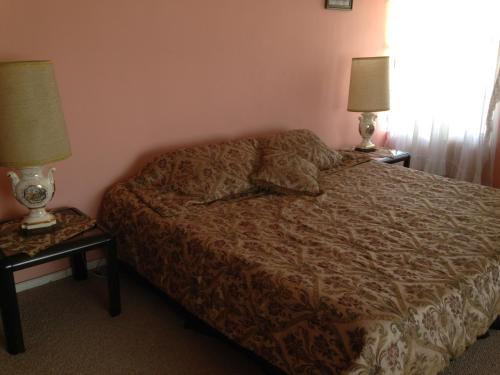 a bedroom with a bed and two lamps on tables at Mansion Samzara Hosteleria in Sangolquí