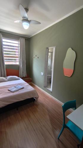 a bedroom with a bed and a chair and a mirror at Hotel Real Paulista in São Paulo