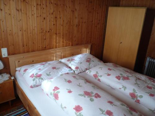 een slaapkamer met een bed met twee kussens erop bij Almhütte Egger Obheimat in Außervillgraten