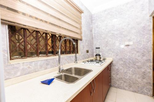 a kitchen with a sink and a window at We care 4u lodge in Kasoa