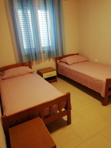 a bedroom with two beds and a window at Apartment Pavin in Poljana