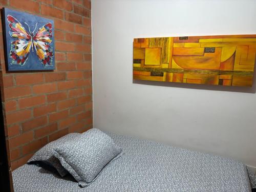 a bedroom with a pillow and a painting on the wall at Casa Roma - La tranquilidad del campo en la Ciudad - RNT 1 0 8 1 3 7- in Salento