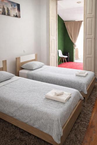 two beds sitting next to each other in a bedroom at Ndussole Guest House in Porto