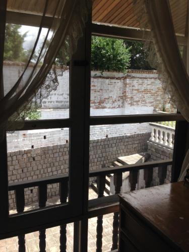 an open window with a view of a brick wall at Mansion Samzara Hosteleria in Sangolquí