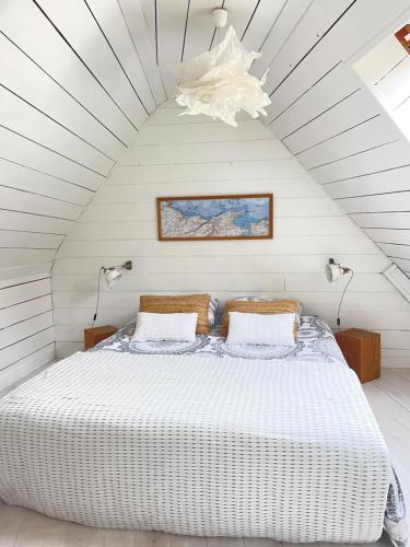a bedroom with a white bed in a attic at White and Sea Lodge in Locquirec