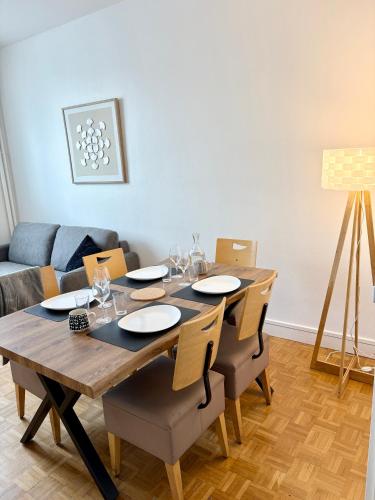 a dining room with a table and chairs and a couch at Le Carré Chic in Limoges