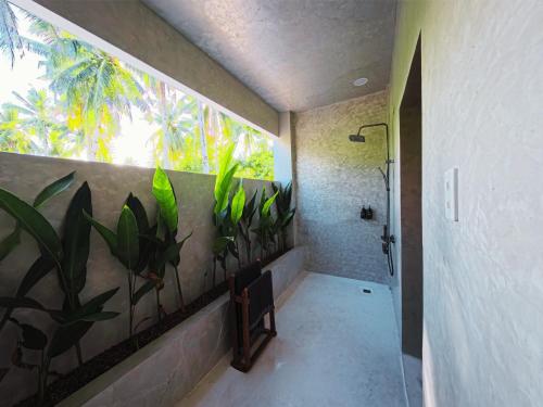 ein Badezimmer mit einer Dusche mit Pflanzen an der Wand in der Unterkunft Casa Oro in General Luna