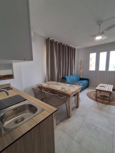 a kitchen and living room with a table and a couch at L'écrin de Saint-pierre - Sunset & Sea View in Saint-Pierre