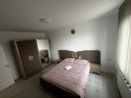 a small bedroom with a bed and a mirror at Dny Luxury in Rădăuţi