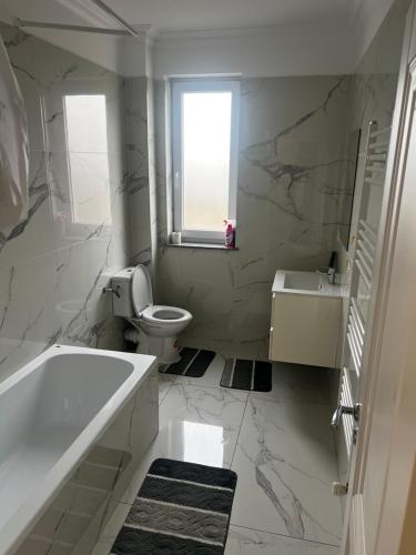 a bathroom with a tub and a toilet and a sink at Dny Luxury in Rădăuţi