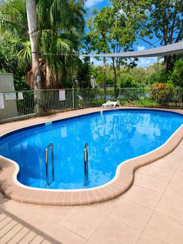 a swimming pool with blue water in a yard at Hidden Gem at The Bay - Resort Pool - 300m to Beach in Urangan