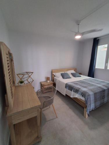 a bedroom with a bed and a table and a desk at L'écrin de Saint-pierre - Sunset & Sea View in Saint-Pierre