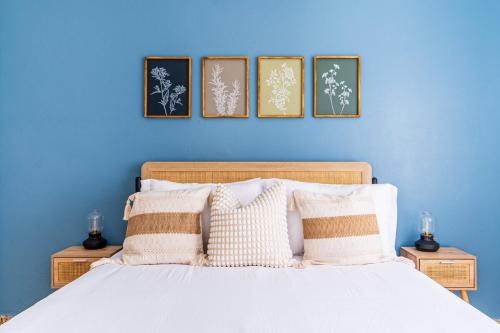 a blue bedroom with a bed with four pictures on the wall at Comfortable & Spacious Mountain Home in Utuado in Cayuco