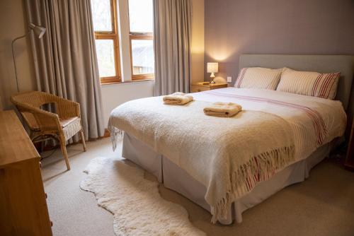 a bedroom with a bed with two towels on it at Morenish Estate in Killin