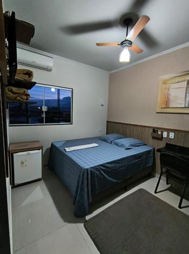 a bedroom with a bed and a ceiling fan at Hotel Graunas in São Carlos