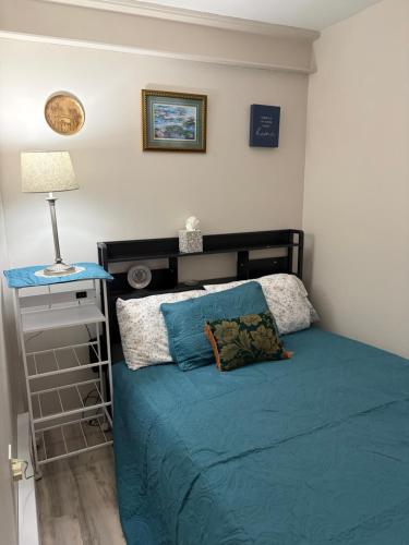 a bedroom with a bed with blue sheets and a lamp at Crawford Suite in Meadville