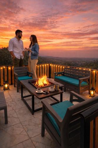 a man and a woman standing on a patio with a fire pit at شاليه غصن in Ajloun