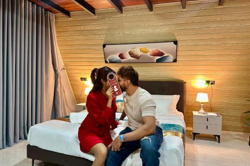a man and a woman sitting on a bed at Bherunda Mount Resort in Kegalle