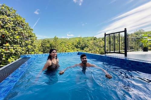 a man and woman swimming in a swimming pool at Bherunda Mount Resort in Kegalle