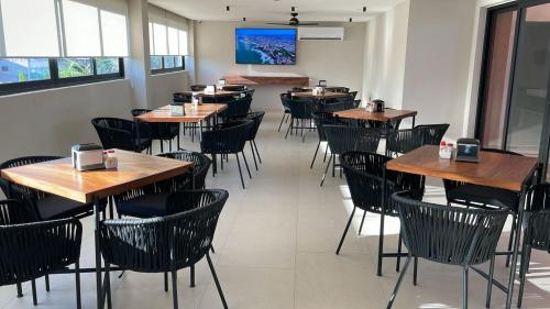 a dining room with wooden tables and chairs at Hotel Portonovo Plaza Malecon in Puerto Vallarta
