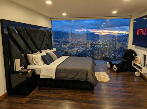 a bedroom with a large bed and a large window at Glass Mansion Breathtaking 180 Panoramic View in Envigado