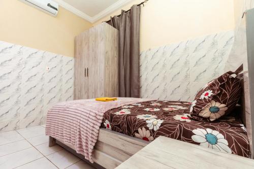 a bedroom with a bed with a wooden headboard at We care 4u lodge in Kasoa