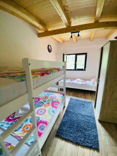a room with two bunk beds and a rug at Lake house Emerald in Jablanica