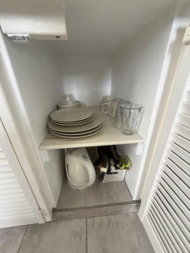 a kitchen with plates and dishes on a shelf at Downtown apartments in Kralendijk