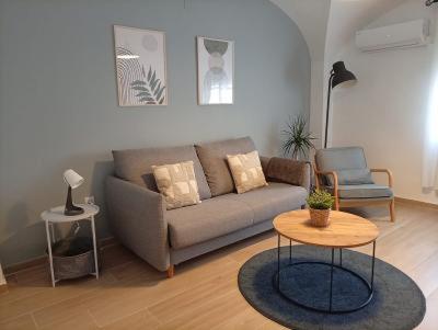 a living room with a couch and a table at Apartamentos La Machacona Plaza Mayor recién reformados in Cáceres