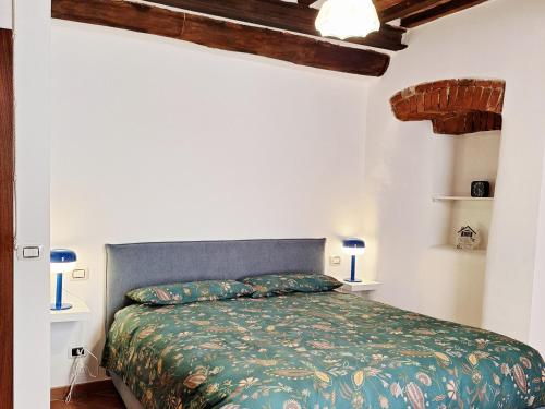 a bedroom with a bed with a green comforter at Apartamento vicolo delle Rose in Castelnuovo Berardenga