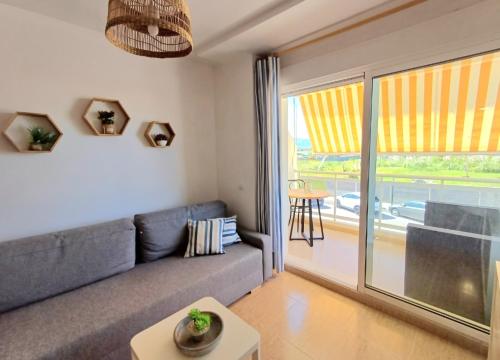 a living room with a couch and a large window at Charli beach in Miramar