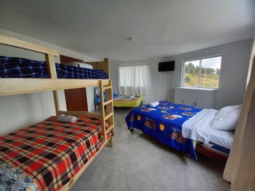 a bedroom with two bunk beds and a window at Hotel CasaBlanca"Tablon de miraflores" in Cuenca