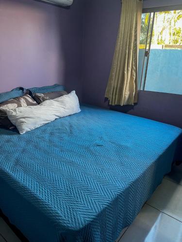 a blue bed in a room with a window at 4 min do Paraguai Casa com piscina e privacidade in Foz do Iguaçu