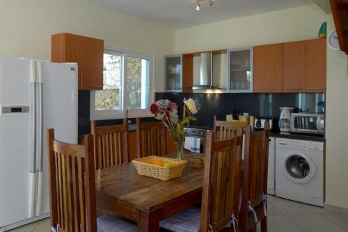 a kitchen with a table with chairs and a refrigerator at Eleonora Villa in Évyiros
