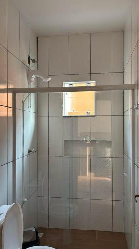 a bathroom with a glass shower with a toilet at Riba House in Imbituba