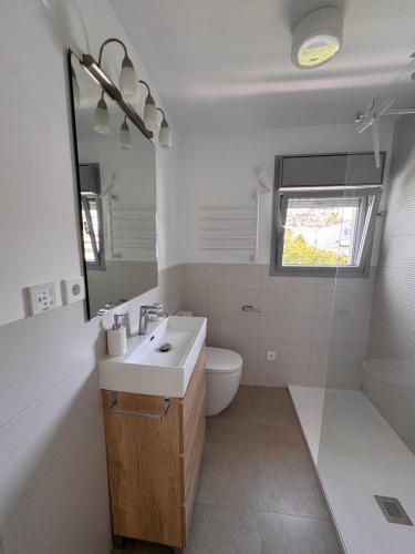 a bathroom with a sink and a toilet and a mirror at Terraza Montaña in Nerja