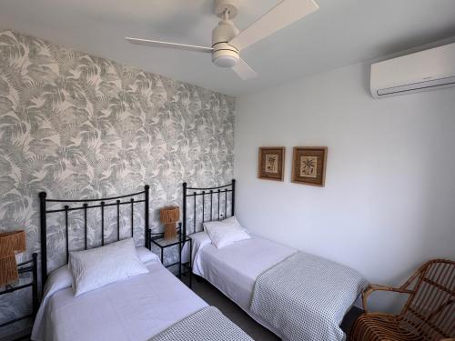 a bedroom with two beds and a ceiling fan at Terraza Montaña in Nerja