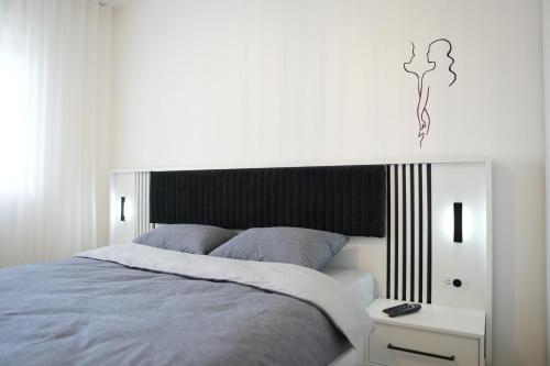 a bedroom with a bed with a black and white headboard at StarLux Residence - Because you deserve it! in Ćuprija