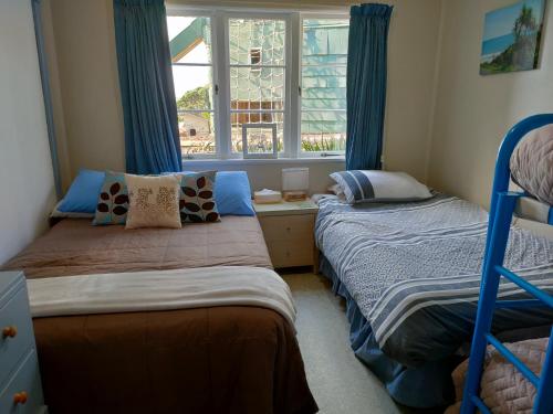 a bedroom with two bunk beds and a window at Raglan Vista in Raglan