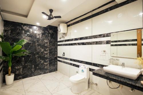 a black and white bathroom with a toilet and a sink at Kubn Retreat in Chandigarh Airport