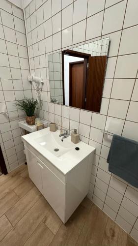 a white bathroom with a sink and a mirror at Villa São João in Funchal