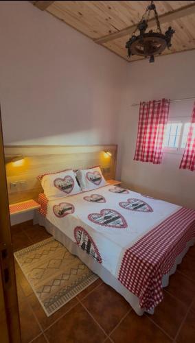 a bedroom with a bed with a red and white blanket at Chalet Suizo in Arcos de la Frontera