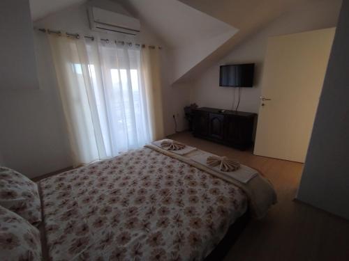 a bedroom with a bed and a large window at Shoposki Guest House in Ohrid