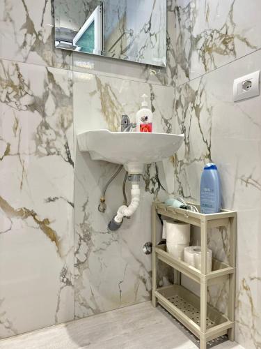 a bathroom with a sink and a marble wall at Villa Adi Saranda in Sarandë