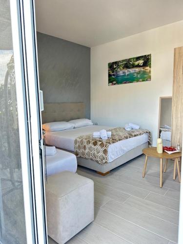a hotel room with two beds and a table at Villa Adi Saranda in Sarandë