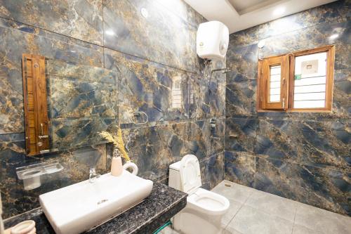 a bathroom with a sink and a toilet at 2Kubn retreat in Chandigarh Airport