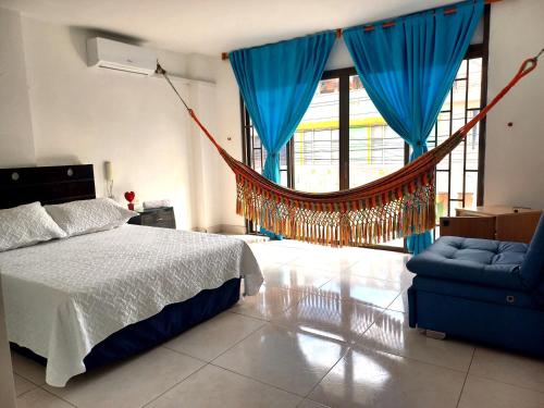 a bedroom with a hammock and a bed and a chair at Hotel Los Balcones de Apulo in Apulo